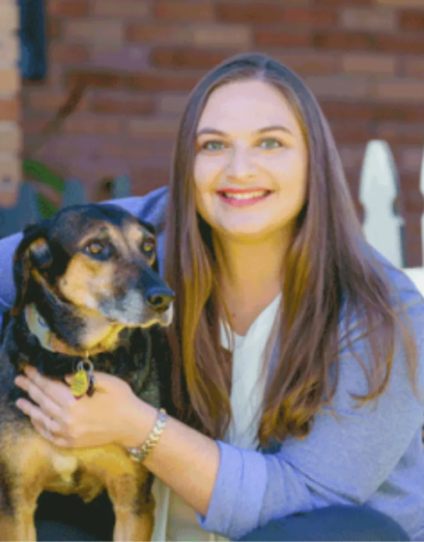 Trayce Womack posing next to a small black and tan dog