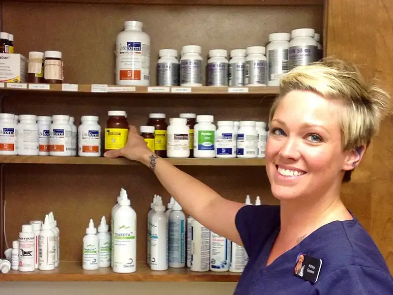 Staff smiling infront of products on shelves