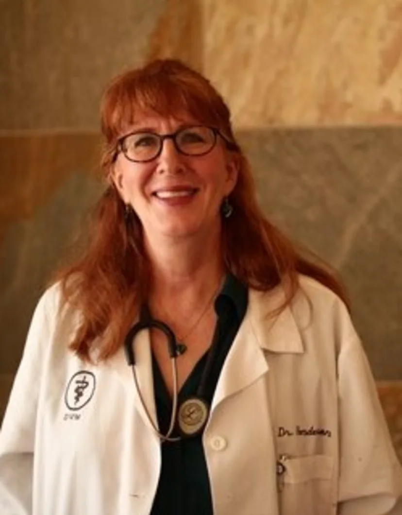 Dr. Lynette Henderson's staff photo from Telegraph Canyon Animal Medical Center posing in front of brick wall