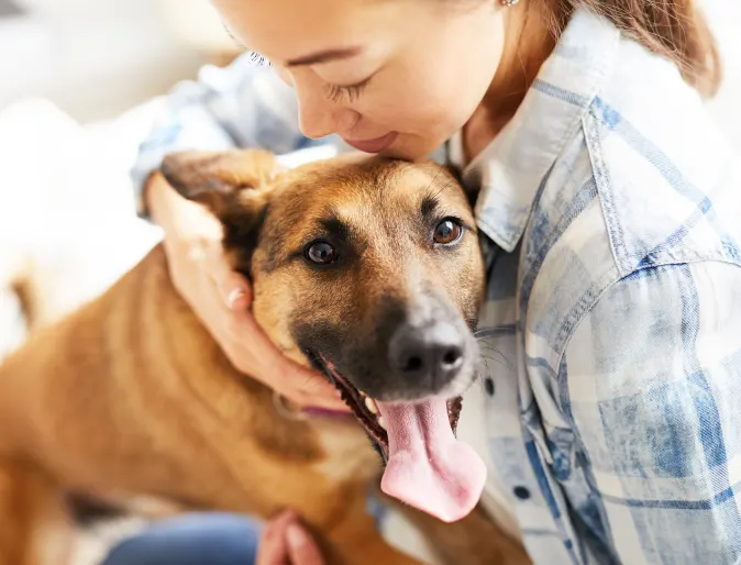 Woman holding dog with its tongue out