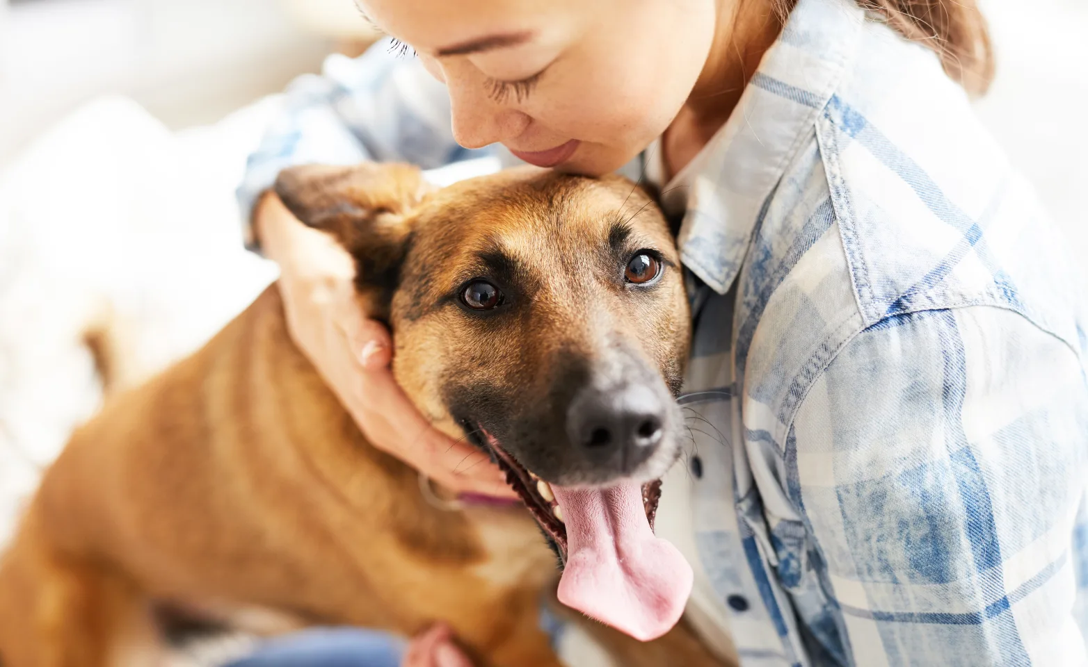 Woman holding dog with its tongue out