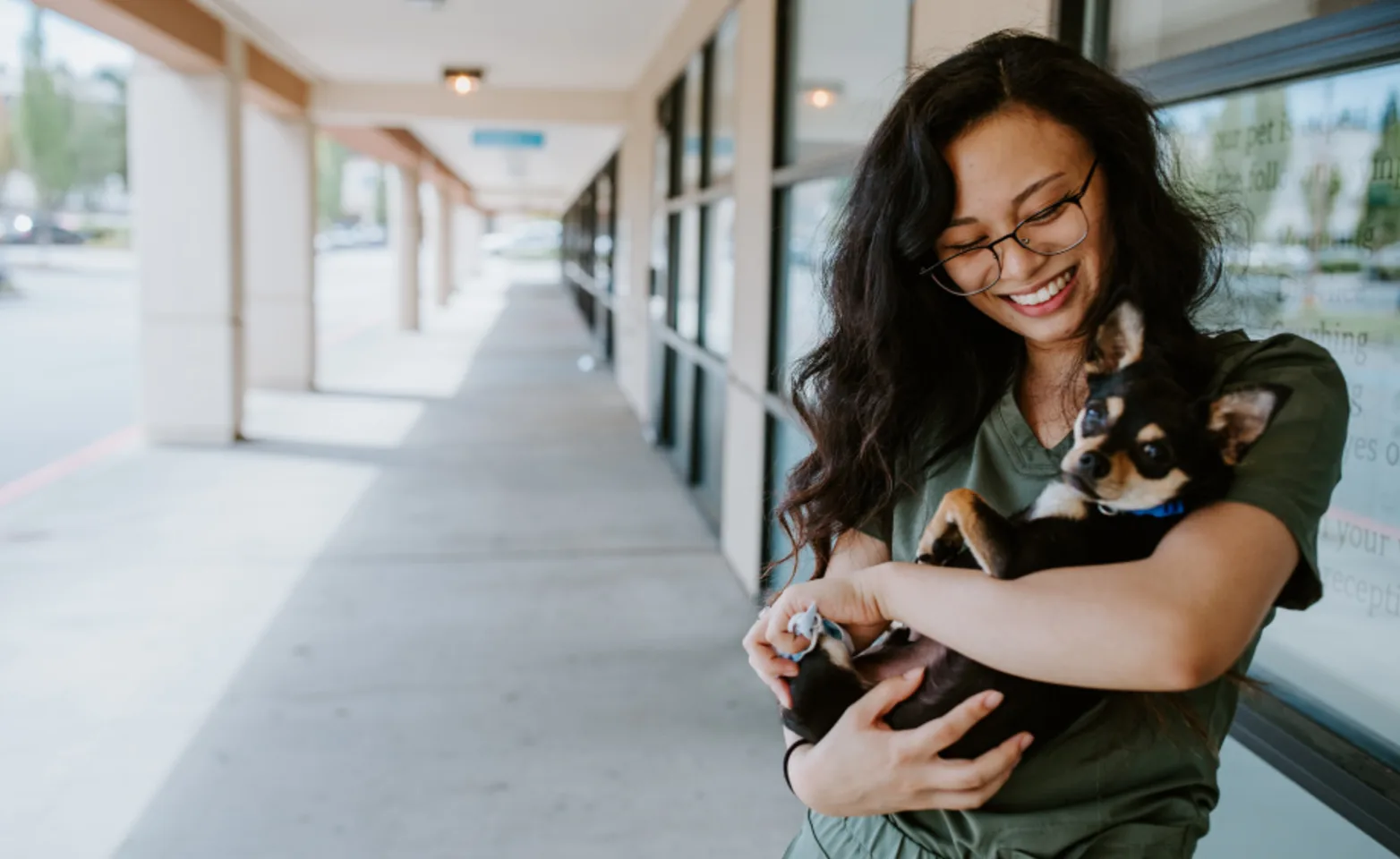 Staff cuddling black and brown dog