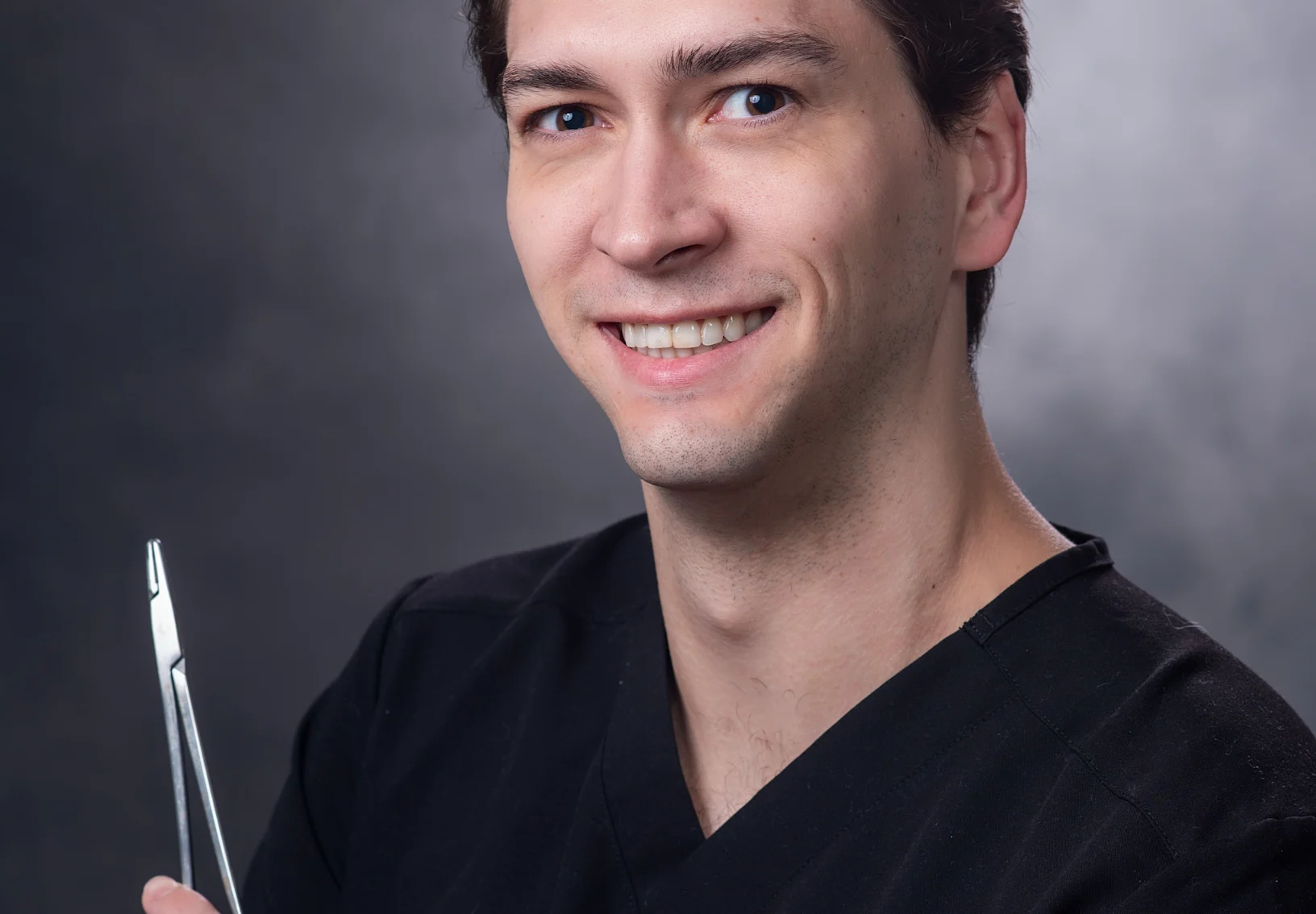 Dr. Connor Pynes smiling holding a medical tool Dr. Connor Pynes smiling holding a medical tool