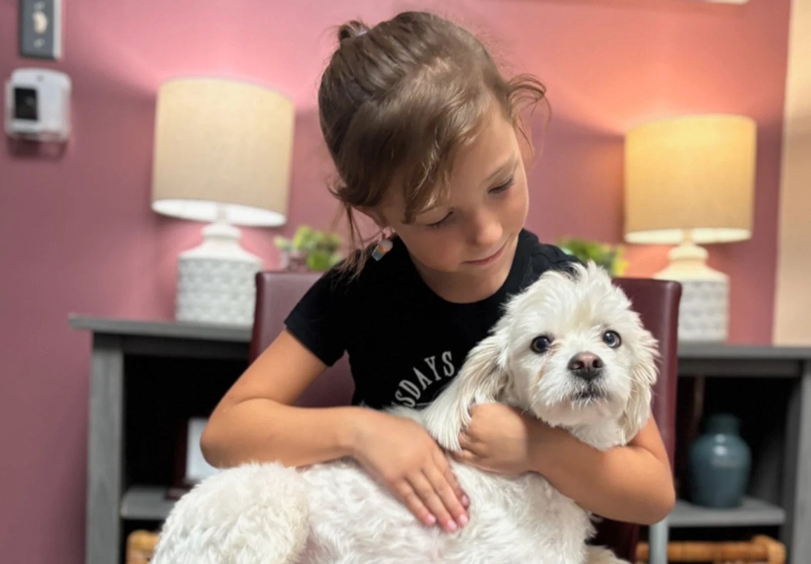 Young girl hugging her white dog Young girl hugging her white dog