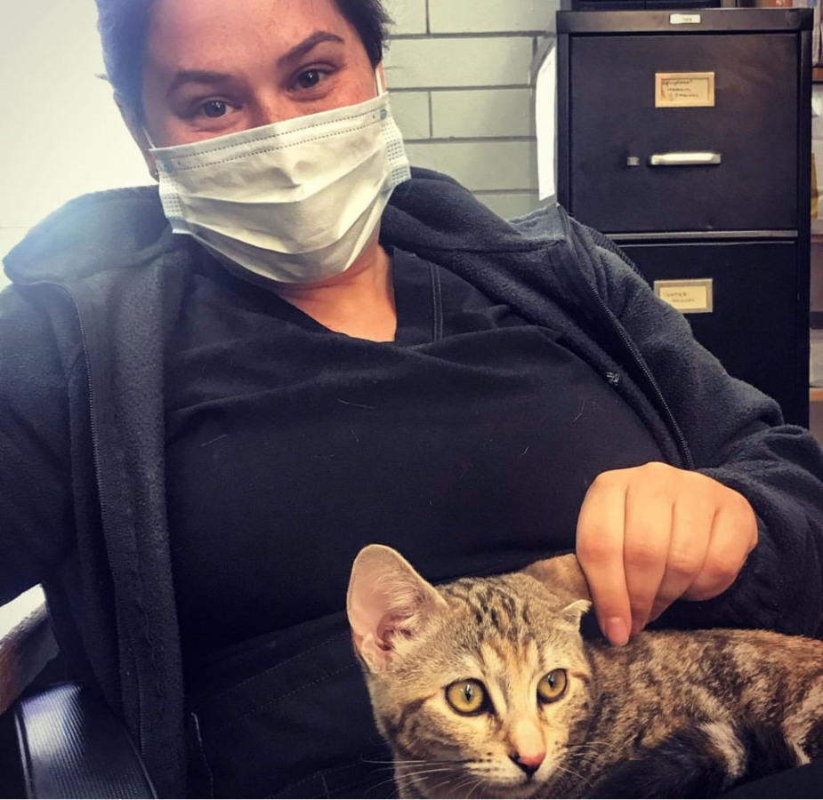Lady with mask on and cat in her lap