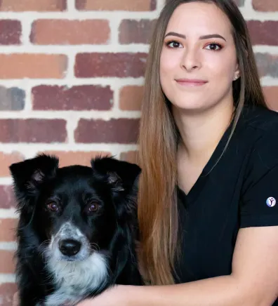 Tessa, staff at Rose Valley Veterinary Hospital, posing with dog