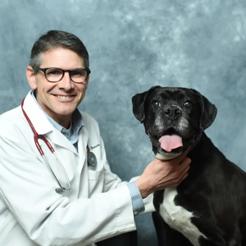 Dr. John A. Benson posing with a dog Dr. John A. Benson posing with a dog