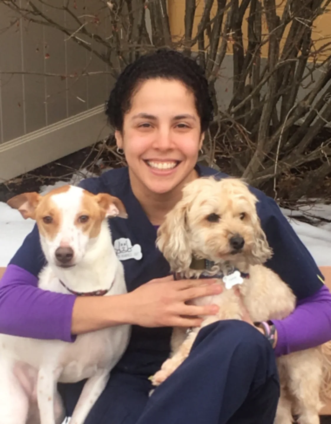 Jeileen sitting on a bench while holding two dogs Jeileen sitting on a bench while holding two dogs