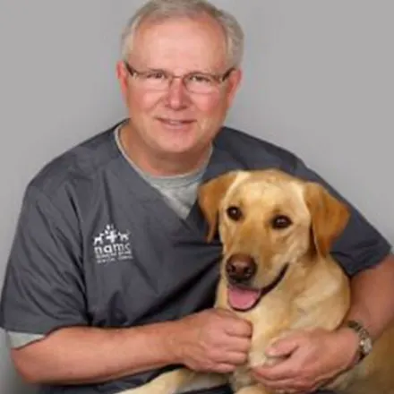 Dr. Kent Forney holding happy dog.