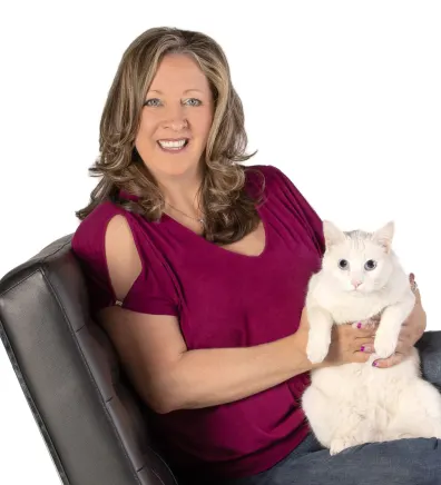 Jennifer Harrington, hospital manager at Apollo North Animal Hospital, holding a white cat on her lap