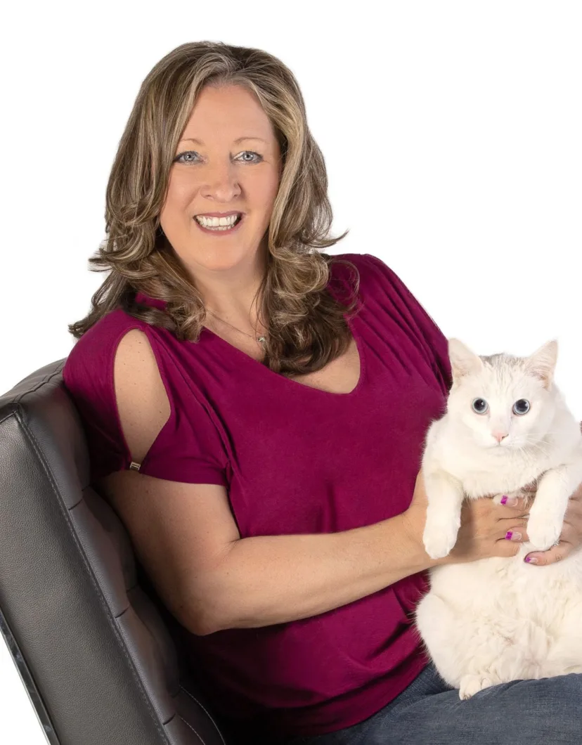Jennifer Harrington, hospital manager at Apollo North Animal Hospital, holding a white cat on her lap