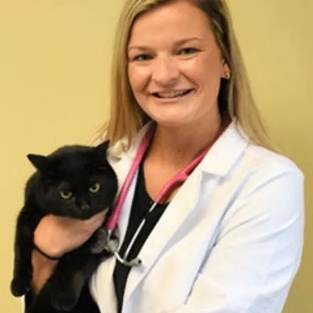 Dr. Abigail holding a black cat.