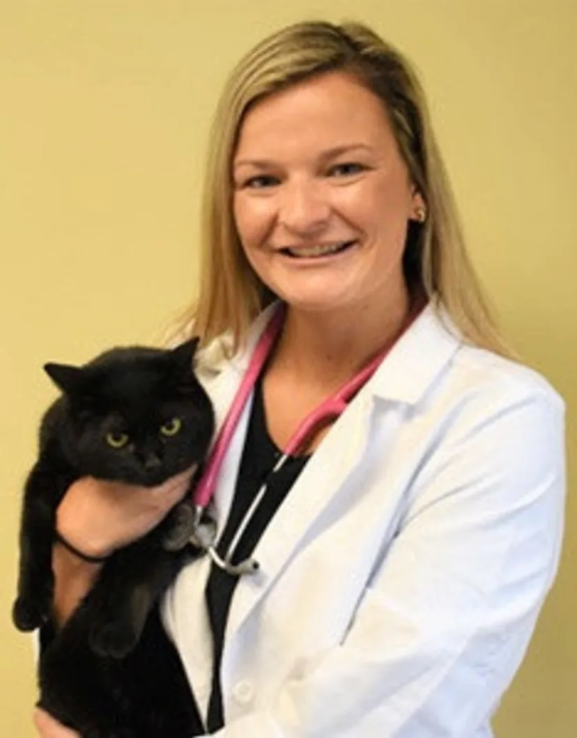 Dr. Abigail holding a black cat.