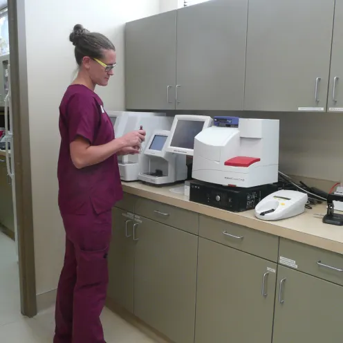 staff member standing in front of equipment that sits atop a counter