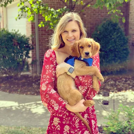 Dr. Folkerts, Veterinarian at Animal Hospital of Towne Lake, holding a small dog