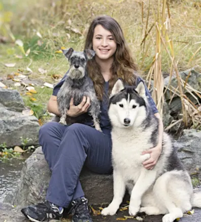 Kristen sitting with one little dog and one big dog Kristen sitting with one little dog and one big dog