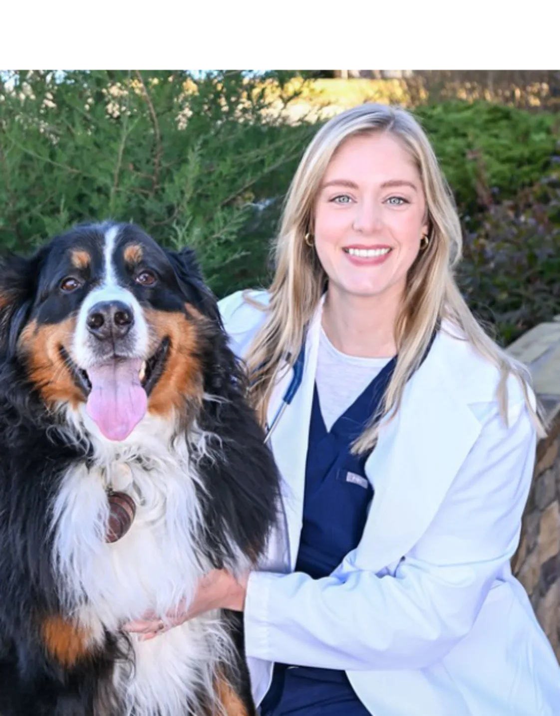 A veterinarian posing with a black dog A veterinarian posing with a black dog