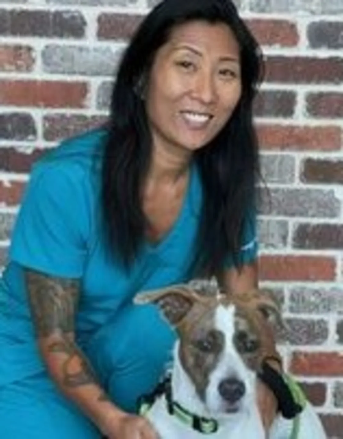 Amy Kunde kneeling next to a white and brown dog Amy Kunde kneeling next to a white and brown dog