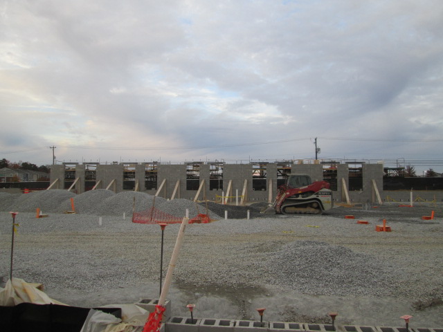 A panoramic view of VVC Short Pump's building in progress with a construction vehicle moving dirt