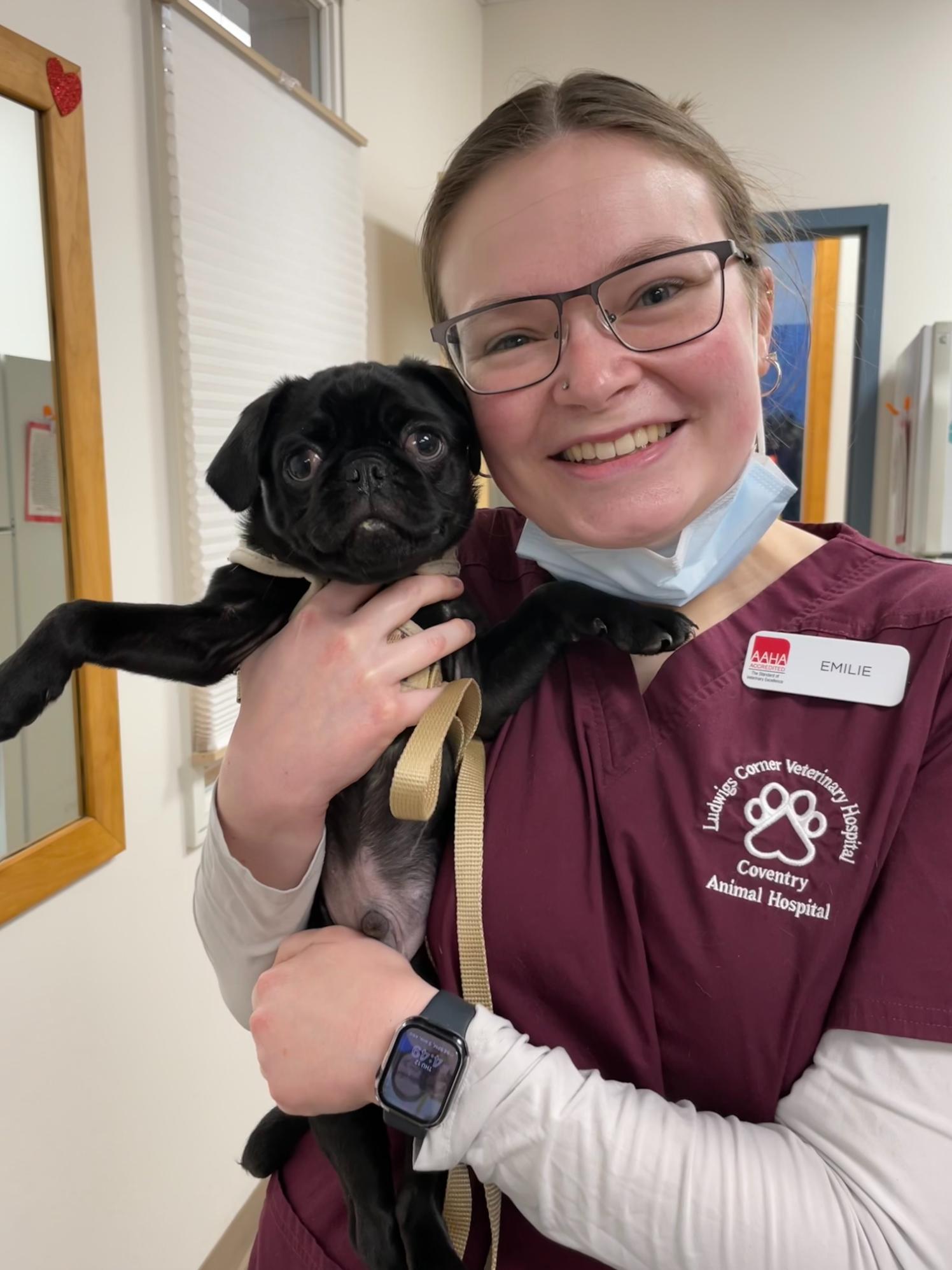 Emilie holding a black pug named Louie