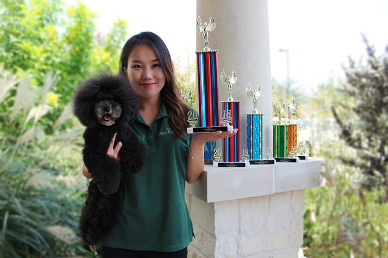 Groomer holding award and dog