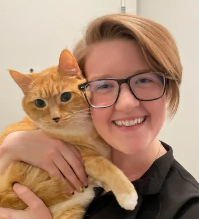 Brittney smiling with an orange cat