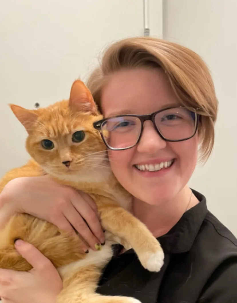 Brittney smiling with an orange cat