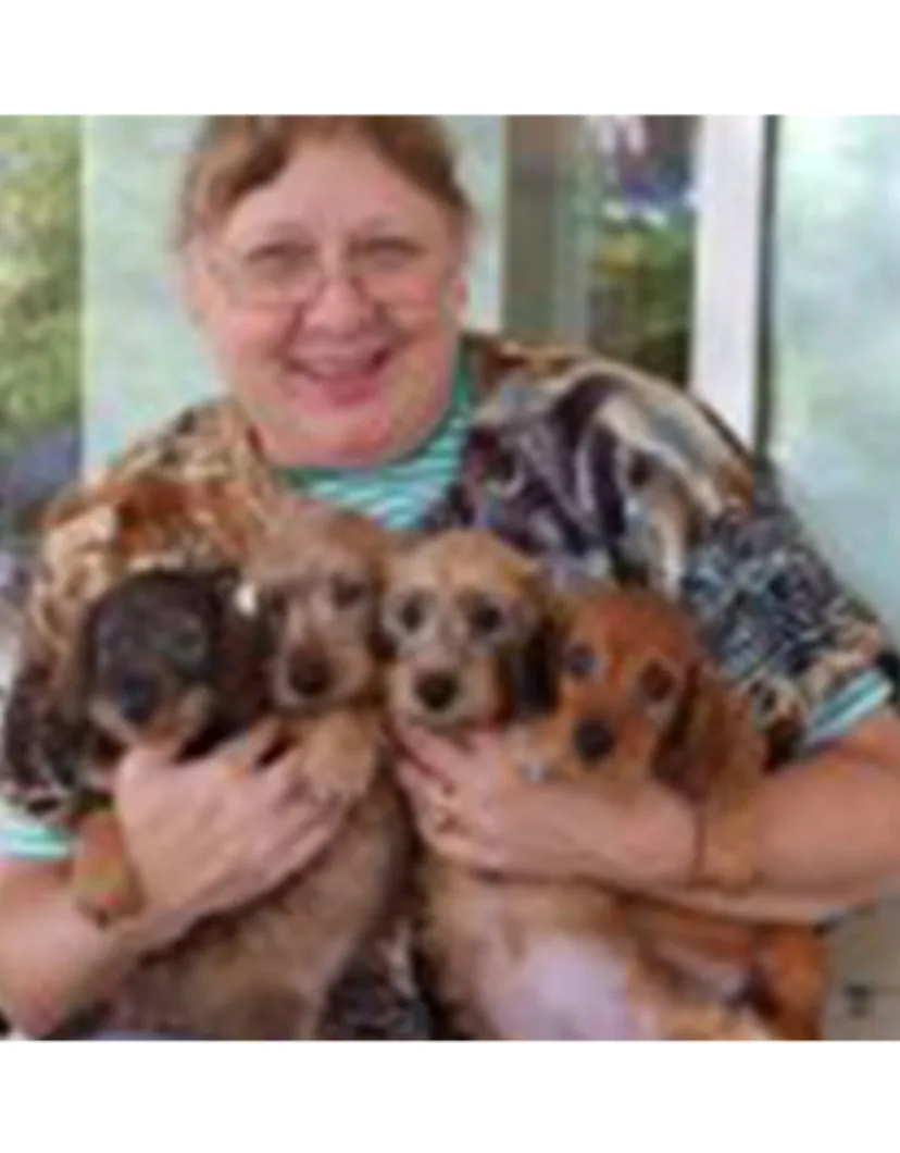 Dr. Valerie Campbell holding four puppies