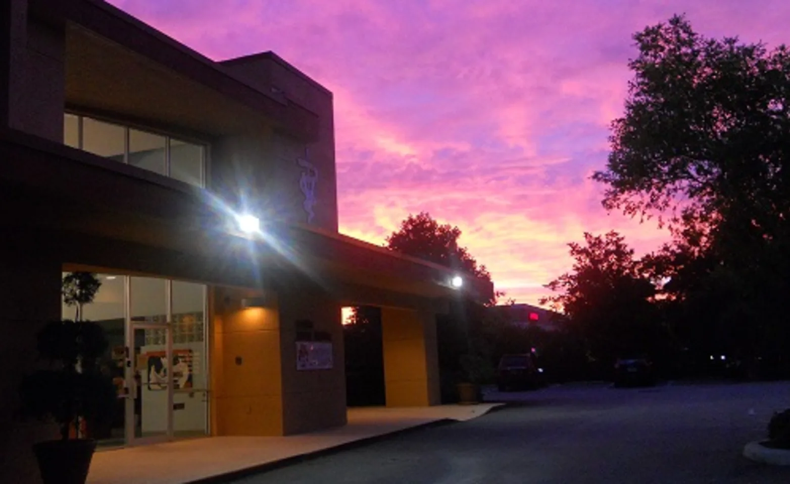 Exterior view of the building at night with a pink sky.