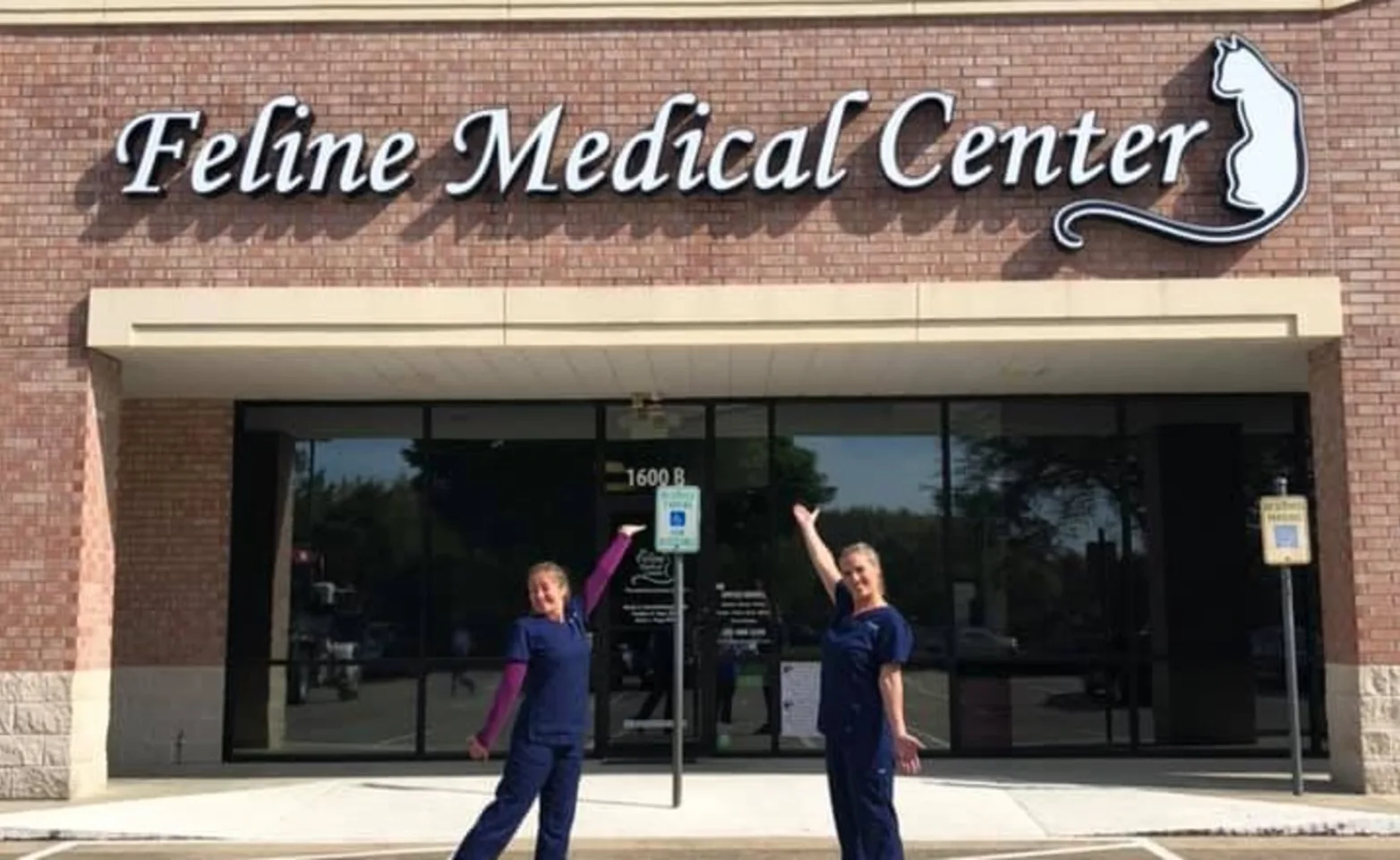 Two veterinary staff members standing in front of Feline Medical Center front entrance
