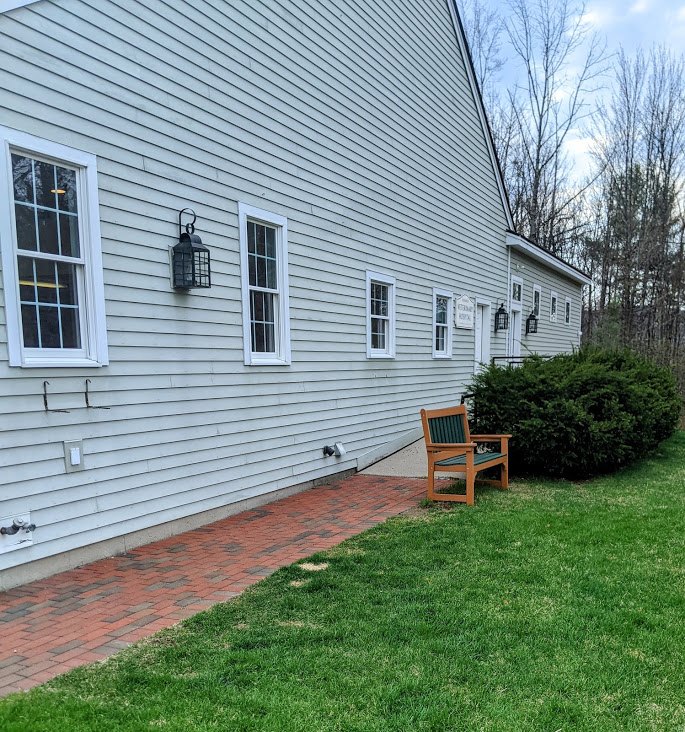 Outside of Henniker Veterinary Hospital where there is a nice sitting bench and a lawn for dogs to run around