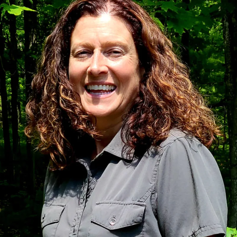 Dr. Pam Buchli smiling standing outside in front of trees Dr. Pam Buchli smiling standing outside in front of trees