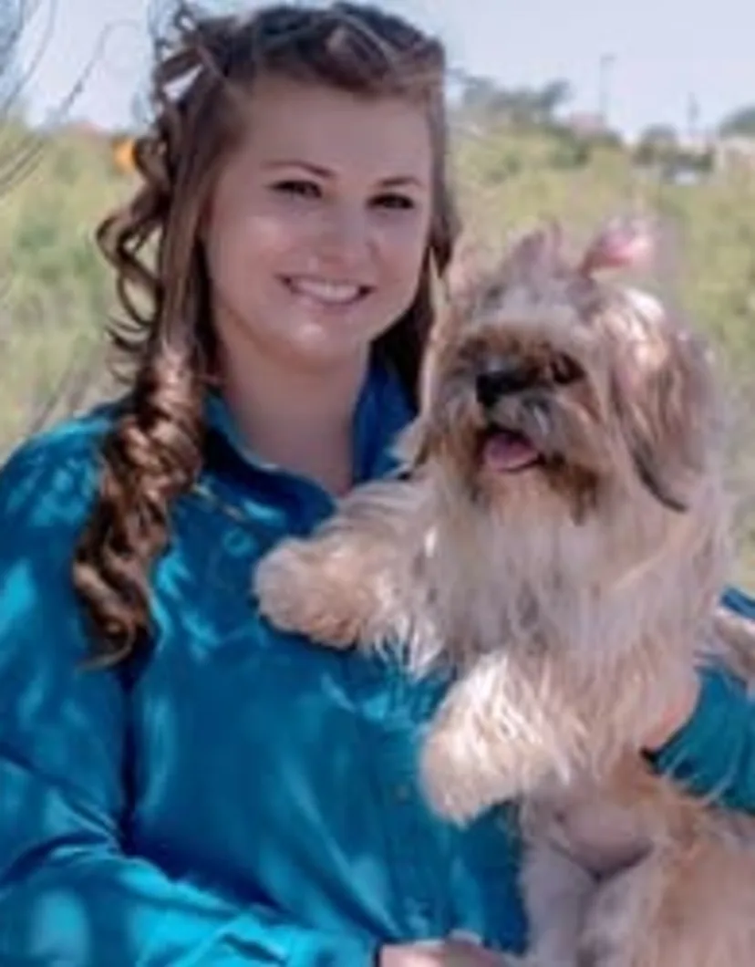Jackie wearing blue and holding a dog.