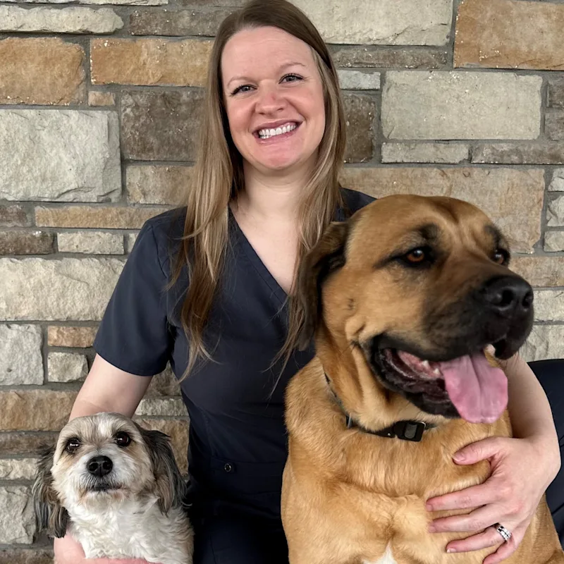 Judy sitting in front of a black backdrop with two dogs Judy sitting in front of a black backdrop with two dogs