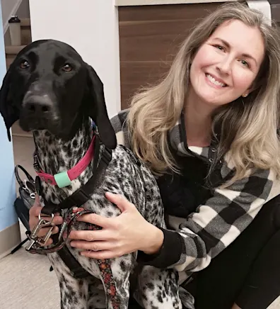 A tall dog with floppy ears standing in a field of tall grass looking to the right A tall dog with floppy ears standing in a field of tall grass looking to the right