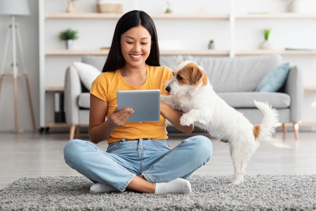Owner and dog looking at tablet screen