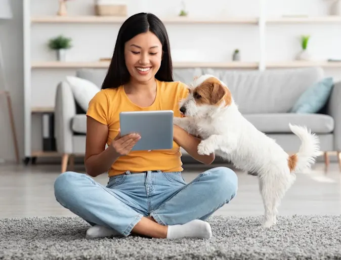 Owner and dog looking at tablet screen Owner and dog looking at tablet screen