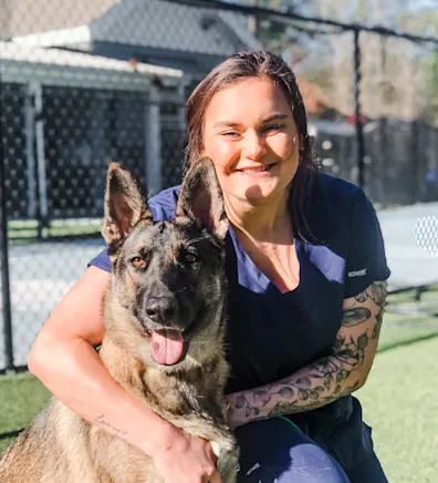 Cammie Fenchel smiling kneeling down next to a German Shepard outside Cammie Fenchel smiling kneeling down next to a German Shepard outside