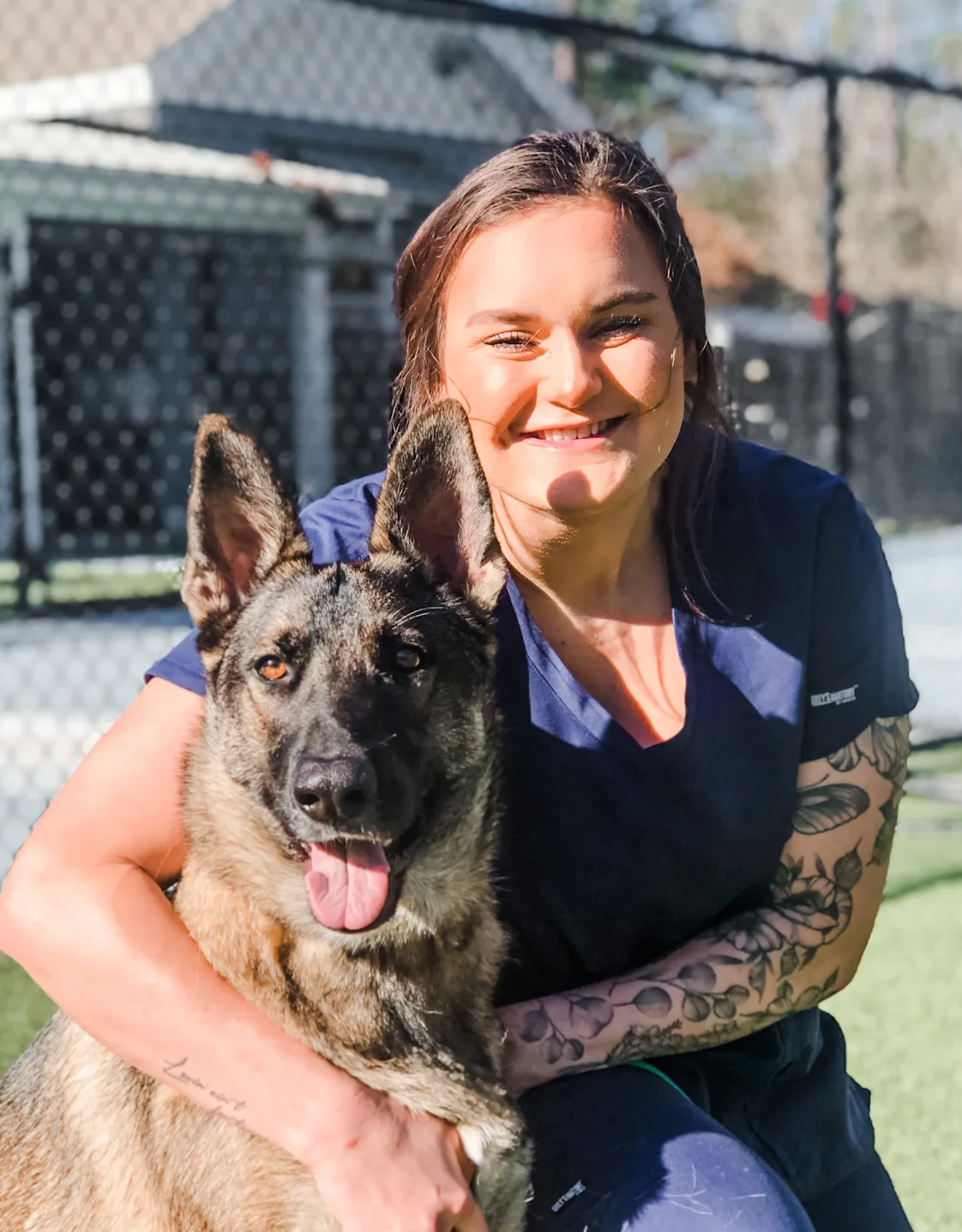 Cammie Fenchel smiling kneeling down next to a German Shepard outside Cammie Fenchel smiling kneeling down next to a German Shepard outside