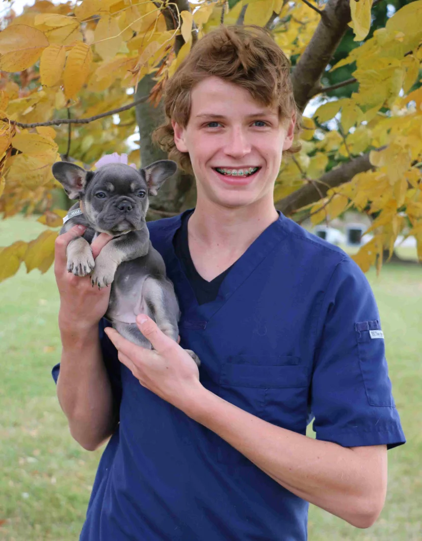 Ben Osmond holding a small gray puppy
