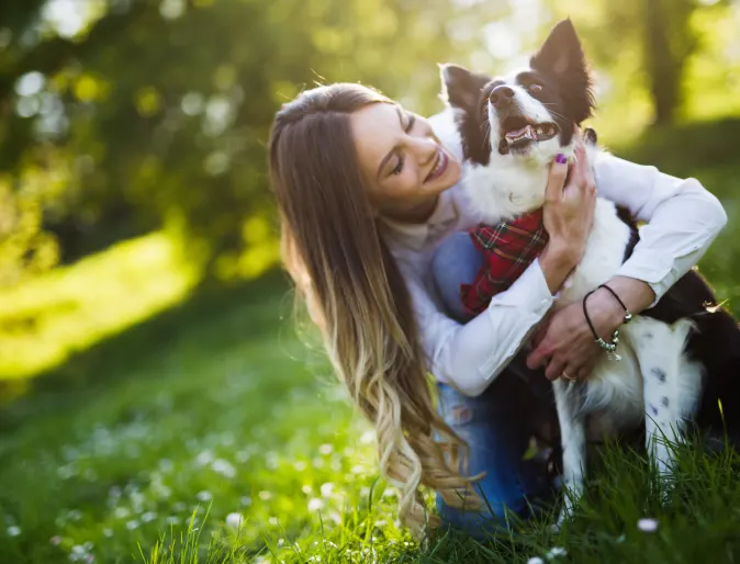 woman holding dog at park