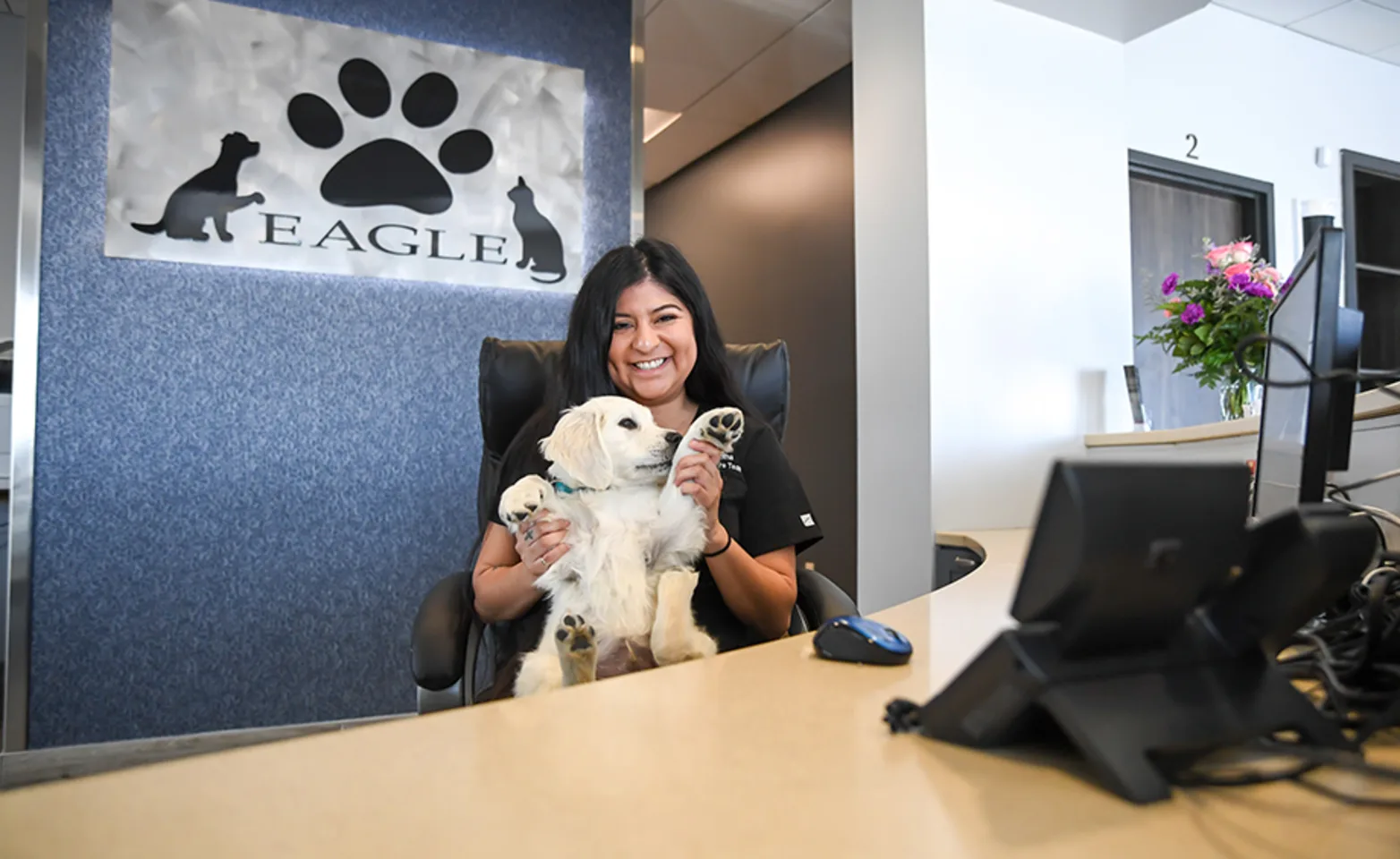 A receptionist posing with a puppy A receptionist posing with a puppy