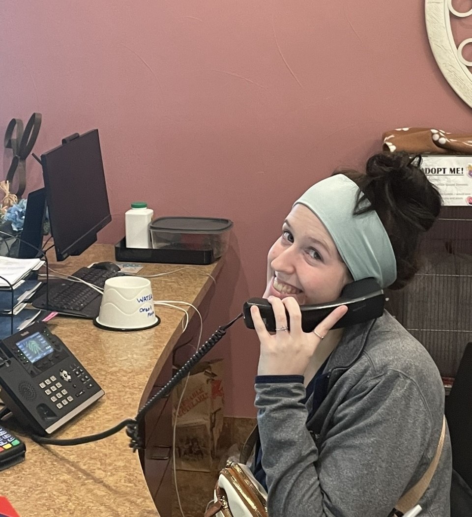 Staff member Malia attending to client on the phone while smiling