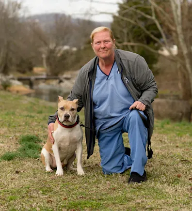 Kim's staff photo from Valley Animal Hospital & Pet Resort where she is outside at a park with her dog