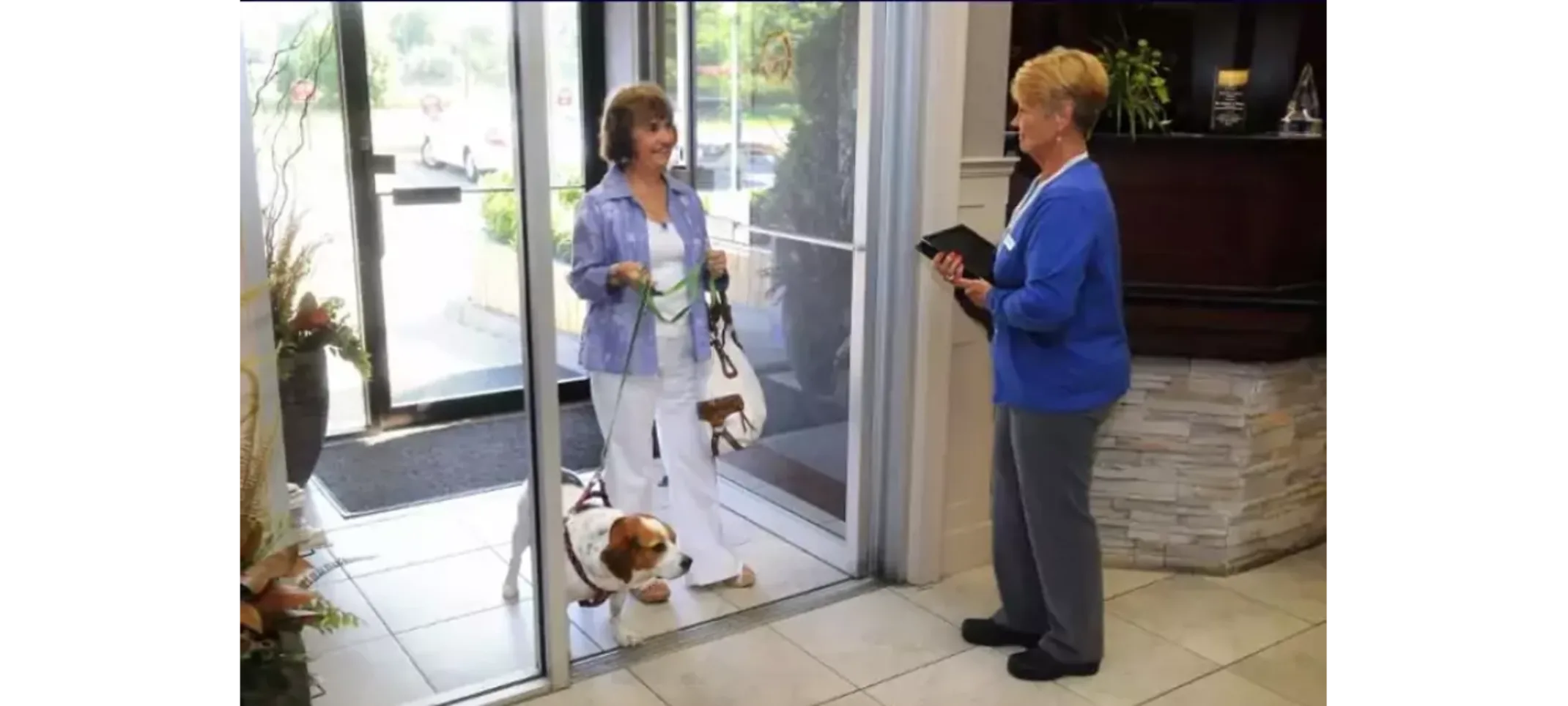Front Entrance Greetings Client with her dog being greeted at the front entrance by a staff member.