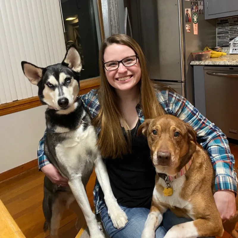 Tabatha sitting down holding two dogs Tabatha sitting down holding two dogs