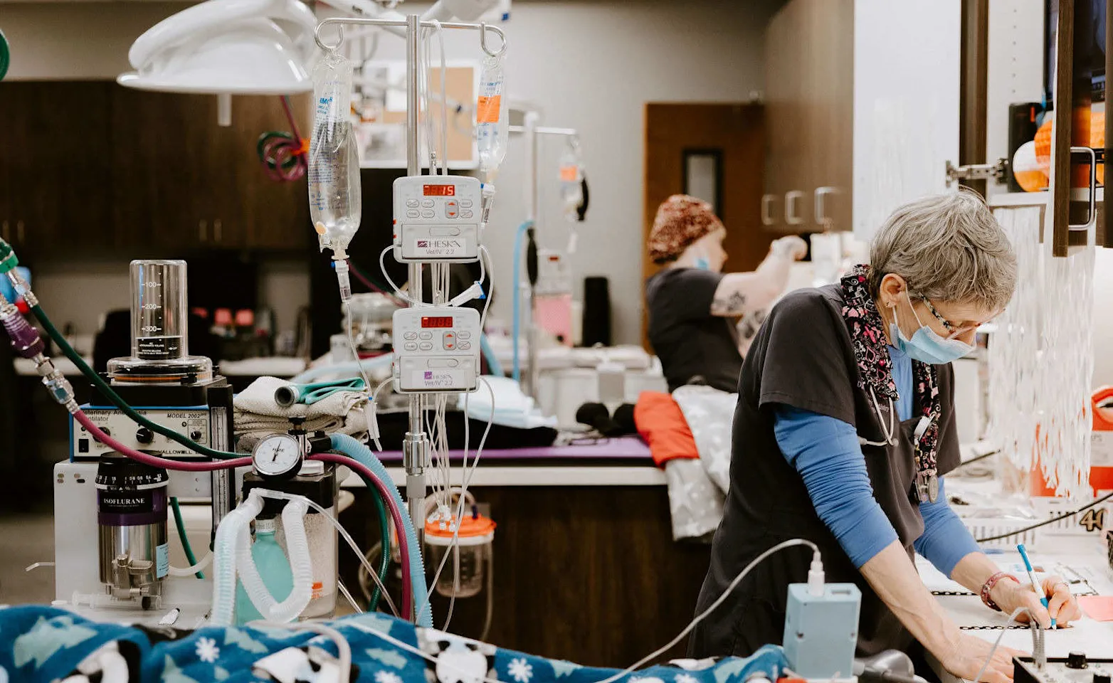 Staff filling paperwork next to an IV stand. Staff filling paperwork next to an IV stand.