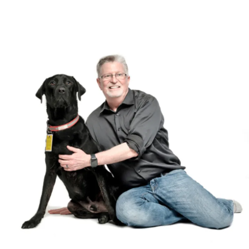 A portrait photo of Dr. John Cruickshank with his dog A portrait photo of Dr. John Cruickshank with his dog