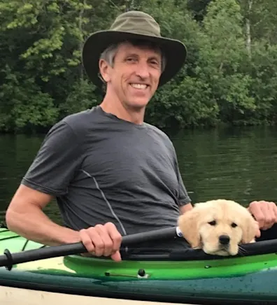 Dr. Dave Heaton posing in a kayak with a small puppy Dr. Dave Heaton posing in a kayak with a small puppy