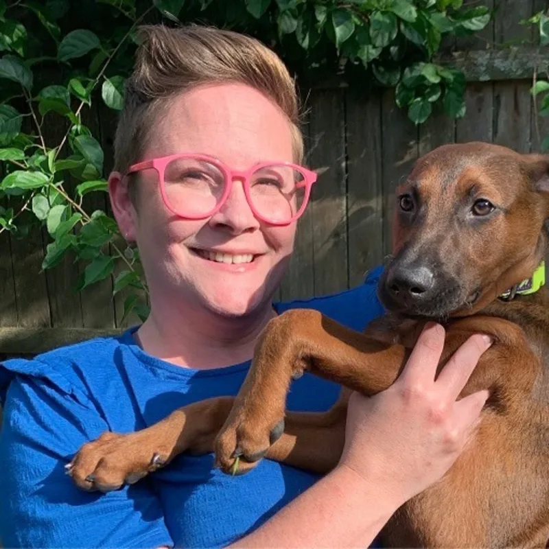 Devon, Assistant Manager of Northampton Veterinary Clinic sitting at a desk answering a phone while a cat is in front of her Devon, Assistant Manager of Northampton Veterinary Clinic sitting at a desk answering a phone while a cat is in front of her